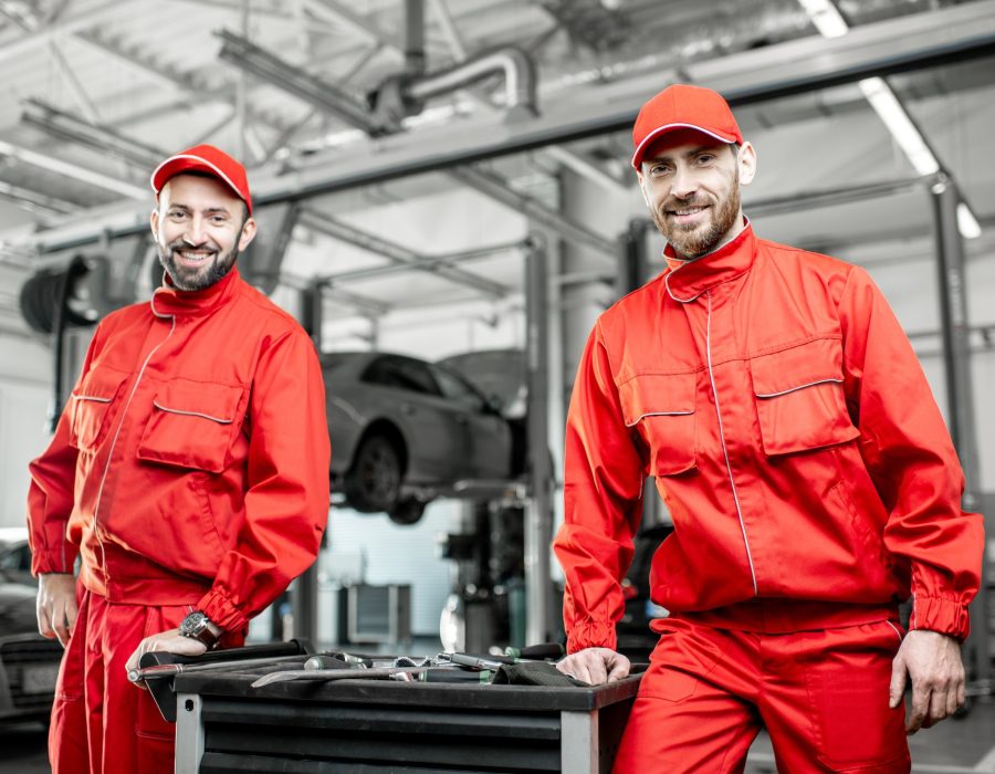 Auto mechanics with wrenches at the car service