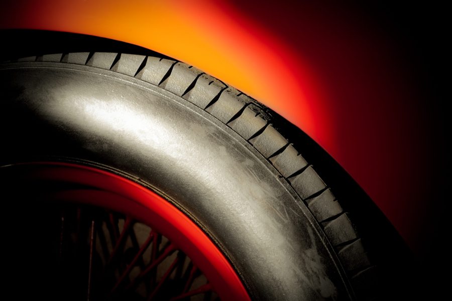 red sportscar wheel and tire in a bright spotlight