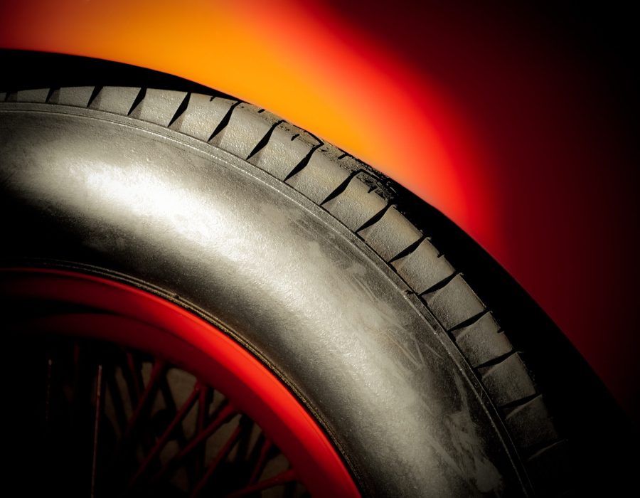 red sportscar wheel and tire in a bright spotlight