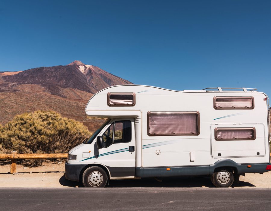 mobile house parked on asphalt route near picturesque view of blue heaven and mountain Teide in Tenerife, Canary Islands, Spain